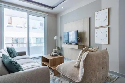 a living room with a couch and a tv at Beach Daze 1-BR Apt By Finikoudes Beach in Larnaka
