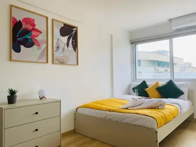 a white bedroom with a bed and a window at Pink Flamingo 1-BR apartment in Larnaca in Larnaka