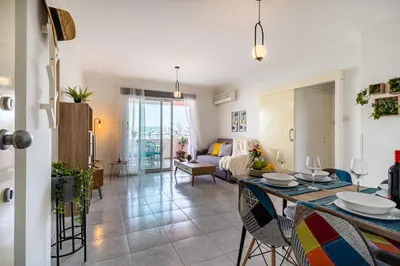 a living room with a table and a couch at Sweet retreat 2-BR Apartment in Mackenzie in Larnaka