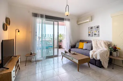 a living room with a couch and a tv at Sweet retreat 2-BR Apartment in Mackenzie in Larnaka