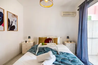 a bedroom with a bed and two night stands at Sweet retreat 2-BR Apartment in Mackenzie in Larnaka
