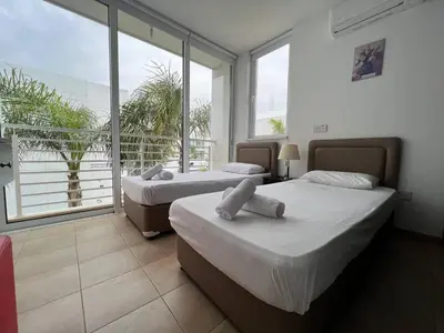 two beds in a room with a large window at Crystal 12 Kapparis 3Bedroom Villa in Paralimni