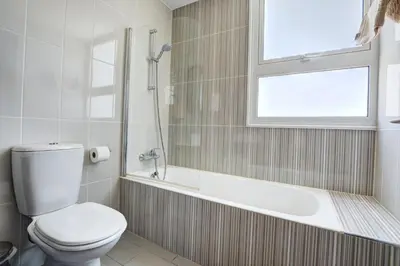 a bathroom with a toilet and a tub and a window at Crystal 12 Kapparis 3Bedroom Villa in Paralimni