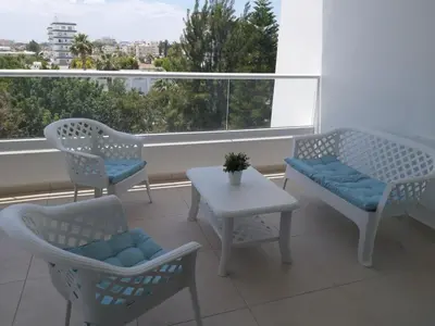 a balcony with chairs and a table and a window at Dinglis Residences 31 in Larnaka