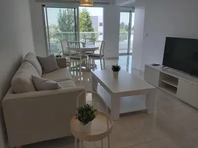 a living room with a couch and a table and a tv at Dinglis Residences 31 in Larnaka