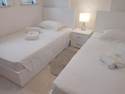 two white beds in a room with a lamp at Dinglis Residences 31 in Larnaka