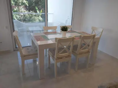 a white dining room table and chairs with a table and a window at Dinglis Residences 31 in Larnaka