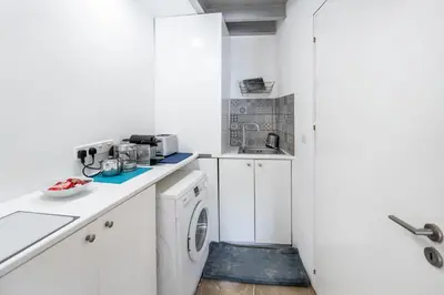 a white kitchen with a washer and dryer at To Hani - Kamara Studio in Nicosia