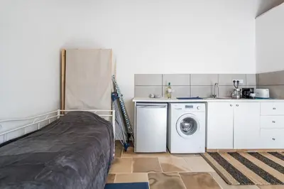 a bedroom with a bed and a washing machine at To Hani - Small Studio in Nicosia
