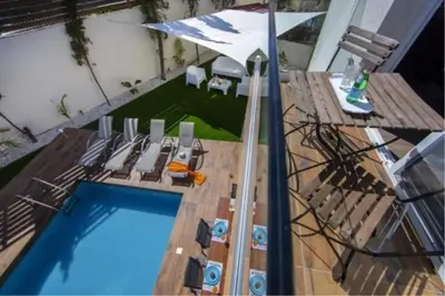 an overhead view of a swimming pool with chairs and an umbrella at Tsokkos Family Villa - Pool Garden 2' Walk to Beach in Protaras