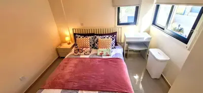 a small bedroom with a bed and a sink at AFRODITI APARTMENTs in Pervolia
