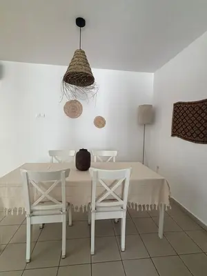 a dining room with a table and two white chairs at Hestia Living in Scala