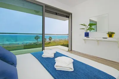 a bedroom with a bed with towels on a blue rug at Villa Napa Seaside in Ayia Napa