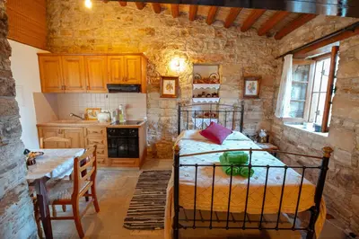 a kitchen with a bed in a stone walled room at Constantias stone houses in Lofou