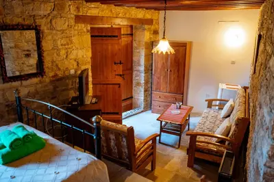 a bedroom with a bed and a table in a room at Constantias stone houses in Lofou