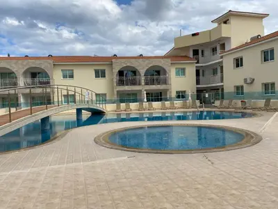 a swimming pool in front of a building with a bridge at Great Kings Resort, Kapparis, Cyprus - Self Catering Apartment, Sleeps 6 in Paralimni
