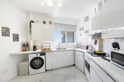 a white kitchen with a washing machine in it at Lovely 3-bedroom apartment in Prokymea court in Limassol