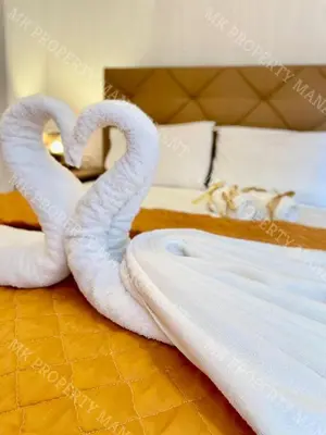 two towels shaped like swans sitting on a bed at Milos City Center Apt. 32 in Larnaka