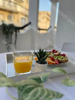 a tray with a plate of food and a glass of orange juice at Milos City Center Apt. 32 in Larnaka
