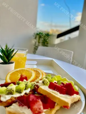 a sandwich with fruit and vegetables on a white plate at Milos City Center Apt. 32 in Larnaka