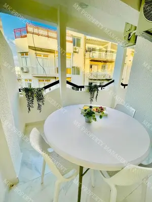 a white table and chairs in a room with a balcony at Milos City Center Apt. 32 in Larnaka