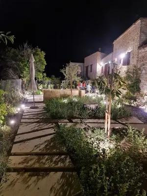 a garden at night with a umbrella and a building at myLofou in Lofou