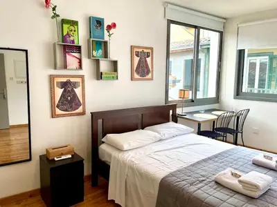 a bedroom with a bed and a table and a window at Irida - Studio Down Town Nicosia in Nicosia