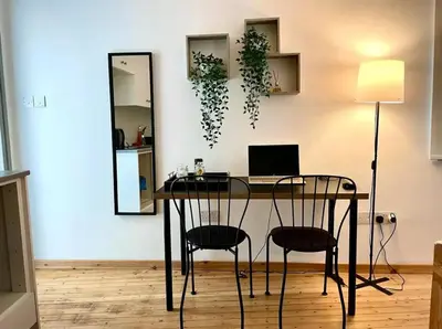 a desk with a computer and two chairs in a room at Irida - Studio Down Town Nicosia in Nicosia