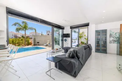 a living room with a couch and a large window at By The Beach - Royal Sapphire Villa in Protaras