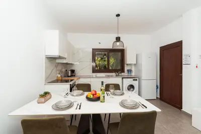 a kitchen with a white table and chairs and a kitchen with a table at SerenityOne - Centrally located One Bedroom Apt in Ayia Napa