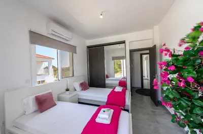 a living room with two beds and a plant at Napa Bay View Villa in Ayia Napa