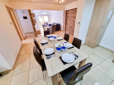 a dining room with a wooden table and chairs at Sunbay City Rooms in Larnaka