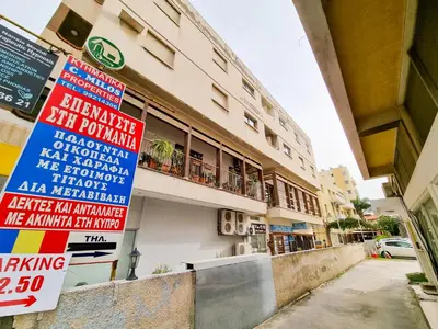 a building with signs on the side of it at Sunbay City Rooms in Larnaka