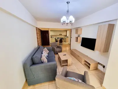 a living room with two couches and a tv at Sunbay City Rooms in Larnaka