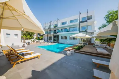a swimming pool with chairs and umbrellas next to a building at De Lux Mythical SPA 9 in Paralimni