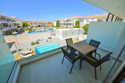 a balcony with a table and chairs and a pool at De Lux Mythical SPA 9 in Paralimni