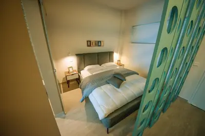 a bedroom with a bed and a mirror at De Lux Mythical SPA 9 in Paralimni