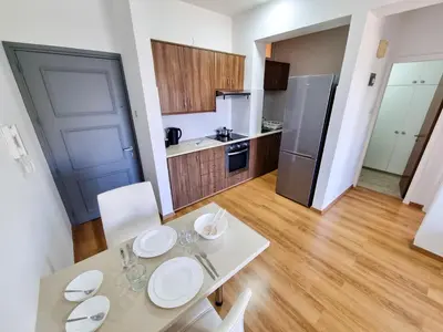 a kitchen with a table and chairs and a refrigerator at Springfield Park Apartment in Larnaka