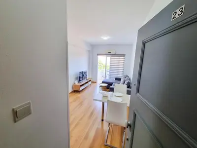 a view of a living room with a table and a couch at Springfield Park Apartment in Larnaka