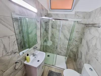 a bathroom with a shower and a sink and a toilet at Springfield Park Apartment in Larnaka