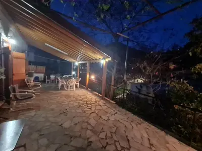 a patio at night with a table and chairs at Elpiniki's Old House in Kalopanayiotis