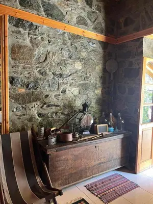 a room with a stone wall with a counter and a chair at Elpiniki's Old House in Kalopanayiotis