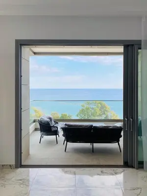 a sliding glass door to a patio with a view of the ocean at The Address-Seafront Luxury 2 Bedroom Residence in Limassol