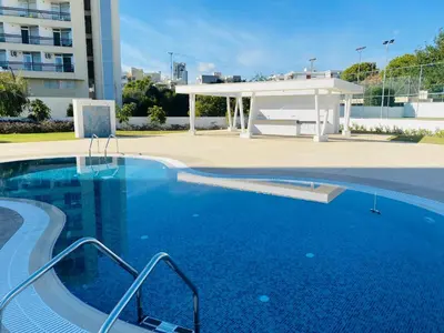 a swimming pool with a gazebo next to a building at The Address-Seafront Luxury 2 Bedroom Residence in Limassol