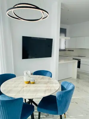 a dining room with a table and blue chairs at The Address-Seafront Luxury 2 Bedroom Residence in Limassol