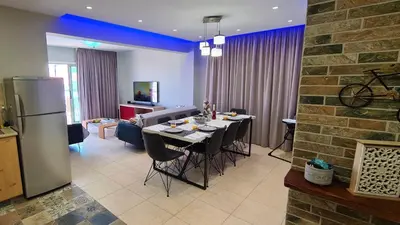 a kitchen and dining room with a table and refrigerator at STAY Kapparis Horizon in Paralimni