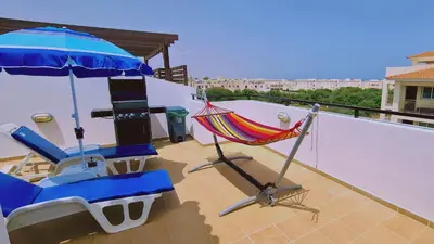 a balcony with a hammock and a chair and an umbrella at STAY Kapparis Horizon in Paralimni
