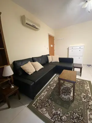 a living room with a black couch and a table at Paralimni in Paralimni
