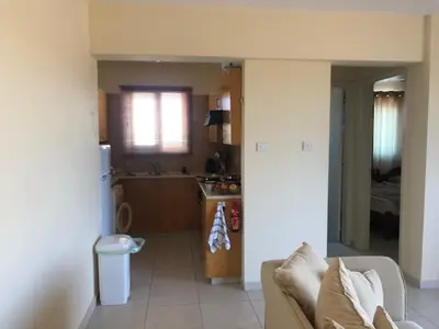 a living room with a couch and a kitchen at Paralimni in Paralimni