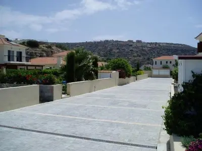 a walkway with houses and a mountain in the background at Katikies 19 in Pissouri